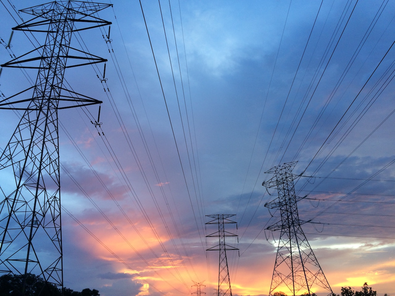 Three powerlines connecting together to distribute high-voltage power to multiple buildings