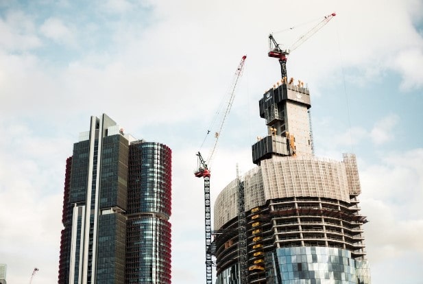 A high-rise building with construction around one as it gets high-voltage equipment installed by a specialist electrical contractor.